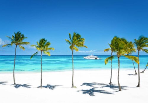 Bahamas charter yacht TOP FIVE II, a 200 foot Royal Hakvoort yacht cruising just off the beach.