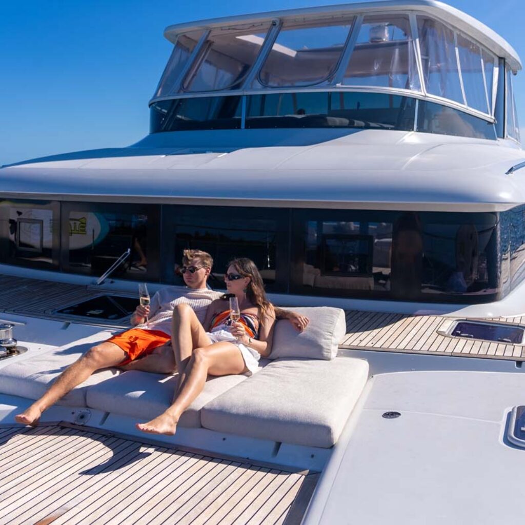 Guests on the bow of PLAYTIME, a 64 foot Lagoon yacht for charter in The Bahamas.